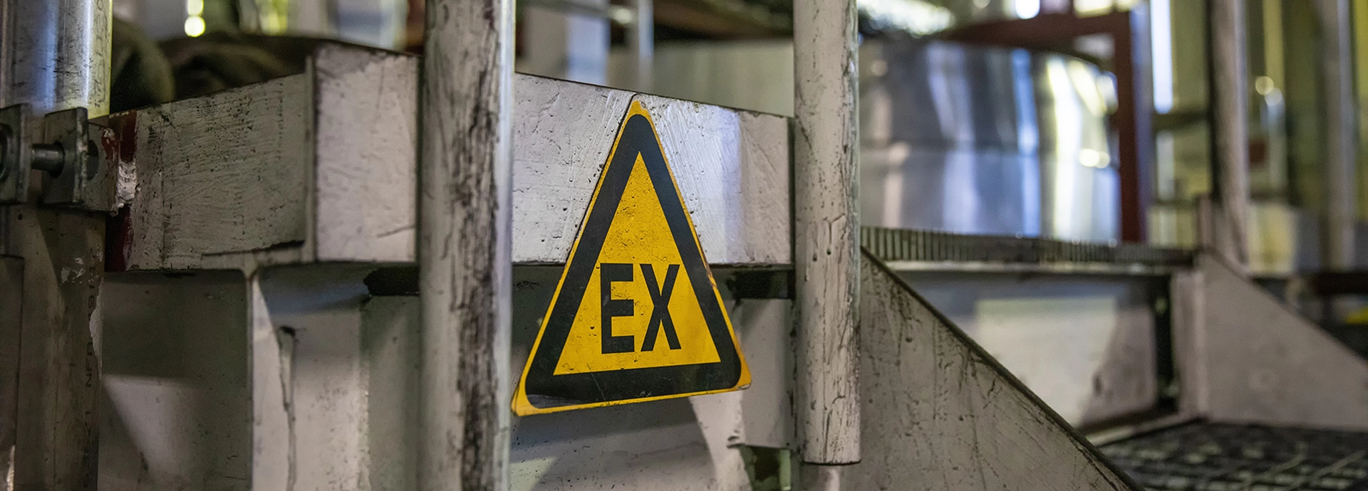 Oznaczenie EX na ż&oacute;łtym tr&oacute;jkącie w środowisku przemysłowym