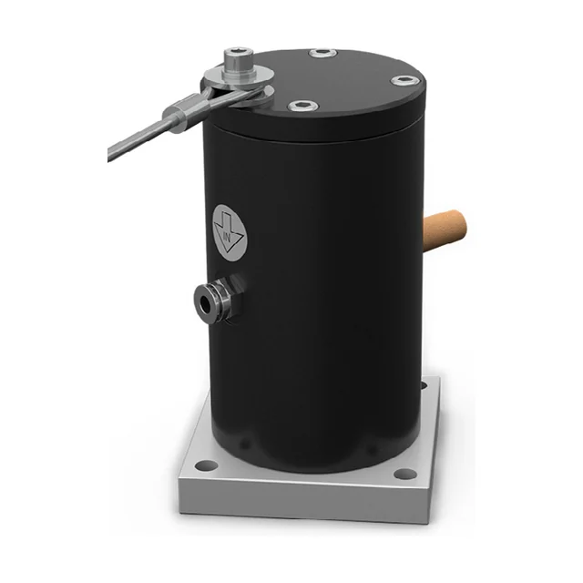 A cushioned piston vibrator on a square aluminium flange, seen from the front at an angle: a matt black cylinder with a black cover on top, a brass silencer and a steel air connection on the side, four holes in the corners of the flange, and on top a threaded stud with a thin rod.