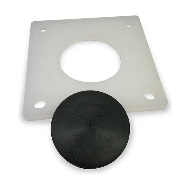 The ATEX kit for the PS: a square, milk-white polypropylene plate with a round hole in the middle and a slotted hole in each corner, and in front of it a black, round tablet with concentric rings in its surface.