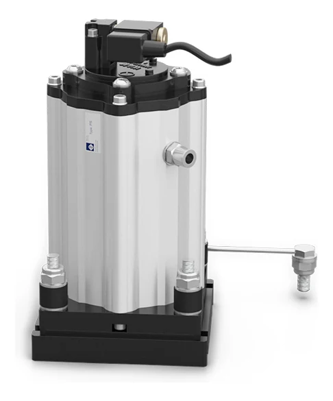 A PS pneumatic hammer of the flat plate type, seen from the front at an angle: a ribbed aluminium housing with a solenoid valve and a black cable on top, an air connection on the side, and the housing bolted down on four studs with black rubber washers over a black square plate.