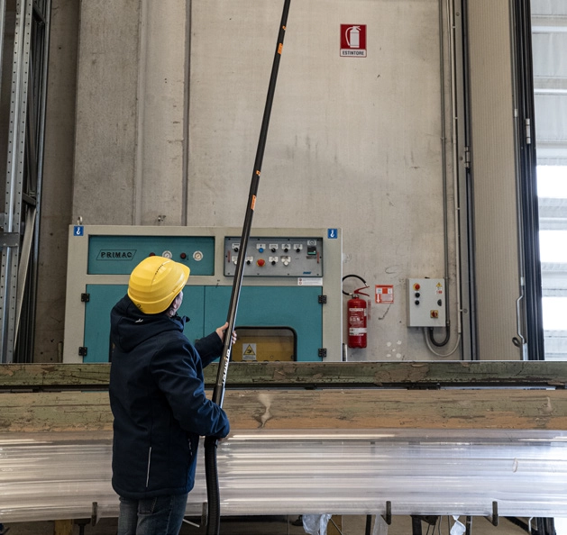 Operator with yellow hard hat using CleanUp telescopic system in industrial hall &ndash; showing reach up to tall machinery