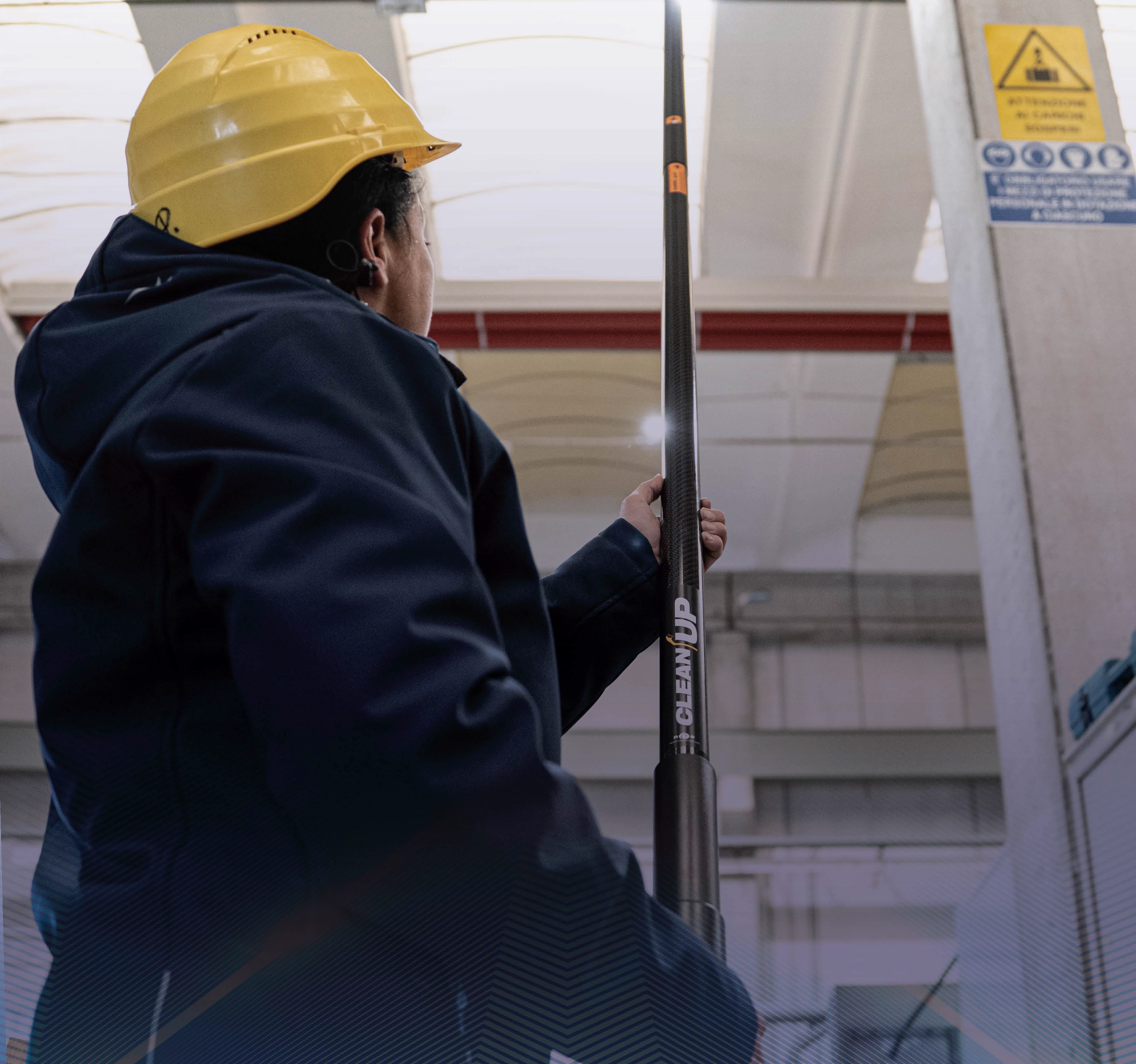 Operator using CleanUp carbon fibre telescopic system for high-reach cleaning in industry